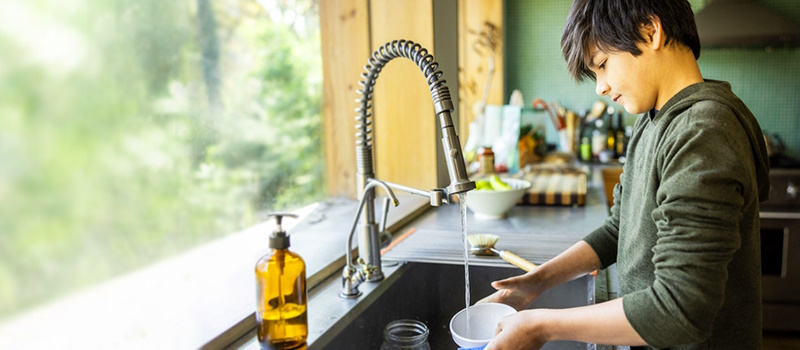 Kid washing dishes