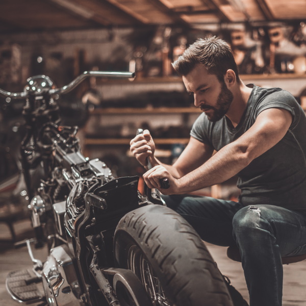man fixing motorcycle